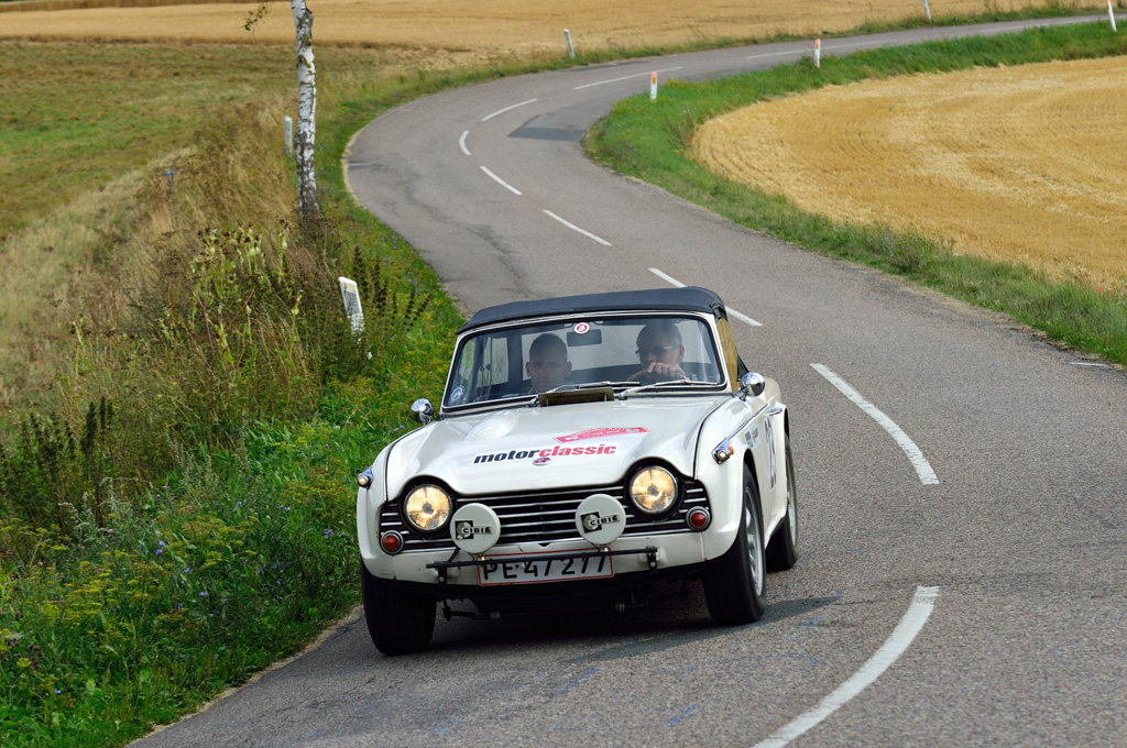 Far og søn, Lars Hjorth fra Frederikssund og Simon Hjort fra Middelfart, lynskudt i deres Triumph TR4A fra 1966 på en østsjællandsk landevej på vej mod sejren i Oresund Rally.
(Foto: Intercom)